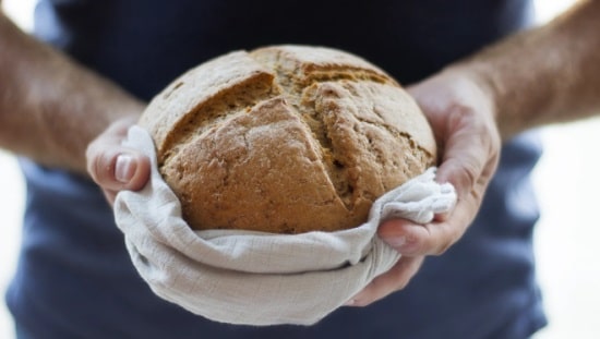 ידיים מחזיקות כיכר לחם